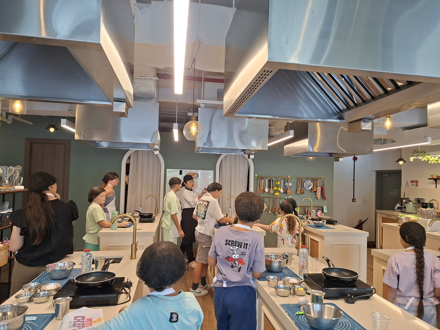 The Petits Chefs Dubai studio kitchen with six team workstations and a main counter
